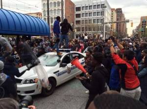 Rioters near Camden Yards in Baltimore smashing the windows and windshields of police cars.